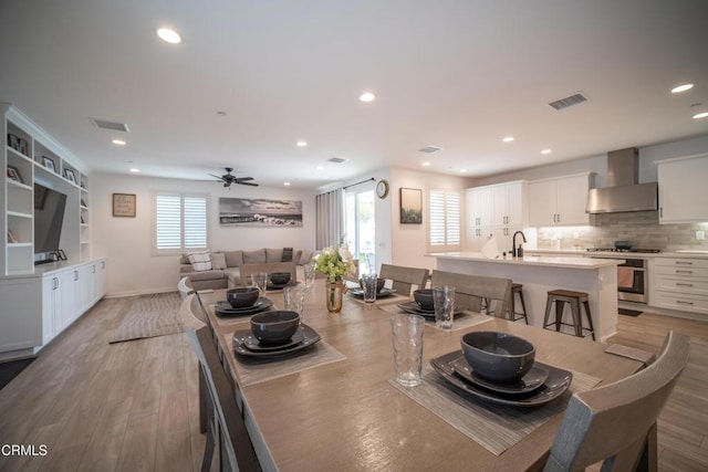 dining area with light wood-style floors, ceiling fan, recessed lighting, and visible vents