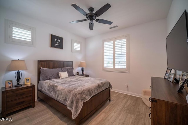 bedroom featuring baseboards, ceiling fan, light wood finished floors, and visible vents
