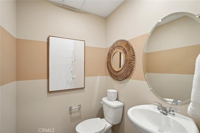 half bathroom with toilet and a sink