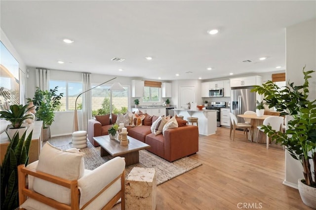 living area featuring recessed lighting, visible vents, and light wood-style floors