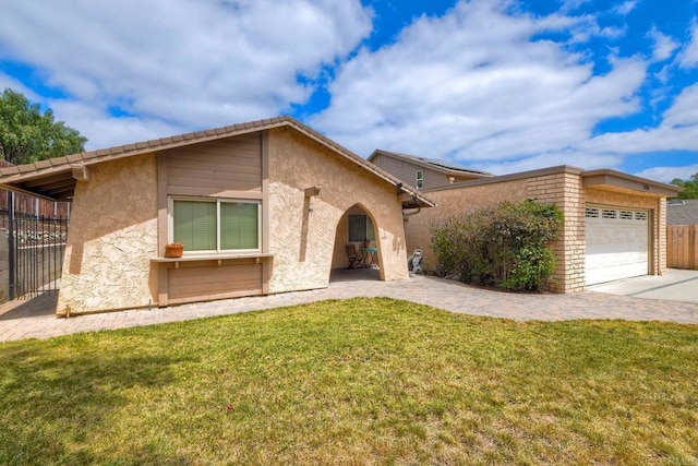 mid-century home featuring a garage, a front lawn, fence, stucco siding, and driveway