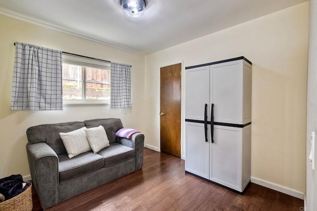 living area with baseboards and dark wood-style flooring