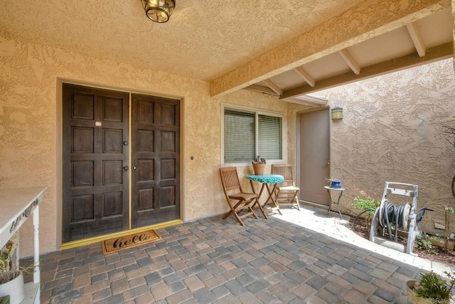 entrance to property with a patio area and stucco siding
