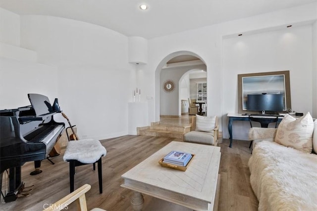living room with arched walkways, recessed lighting, and wood finished floors