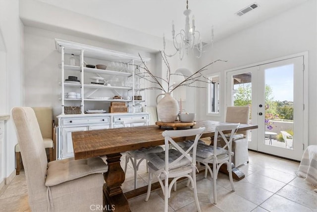 dining area with visible vents, light tile patterned floors, a notable chandelier, and french doors