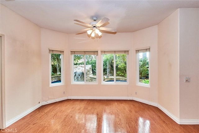 empty room with baseboards, ceiling fan, and wood finished floors