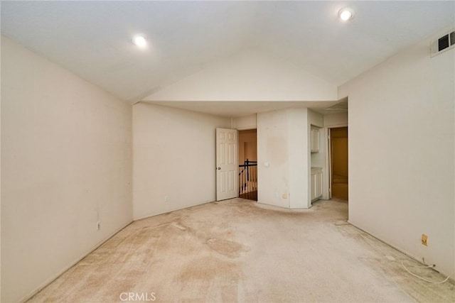unfurnished room featuring visible vents, vaulted ceiling, recessed lighting, and light colored carpet