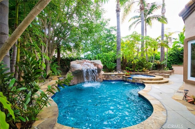 view of swimming pool with a patio and a pool with connected hot tub