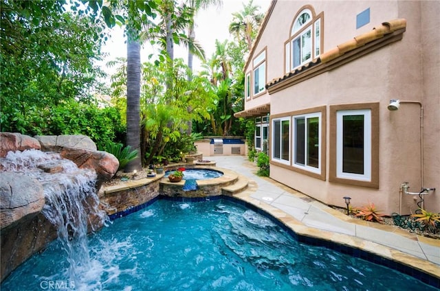outdoor pool with an in ground hot tub and area for grilling