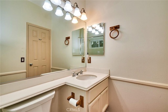 half bathroom with vanity, toilet, and a chandelier
