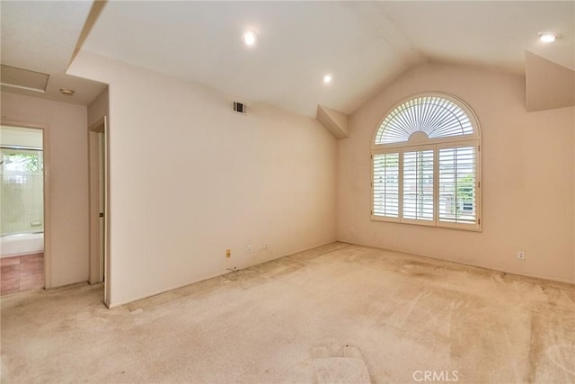 unfurnished room featuring visible vents, carpet floors, and vaulted ceiling