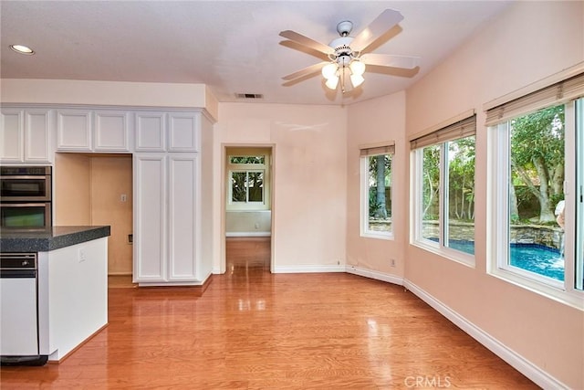 kitchen featuring visible vents, a ceiling fan, light wood-style flooring, and double oven