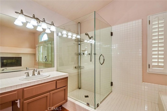 full bathroom featuring a shower stall, a healthy amount of sunlight, and vanity