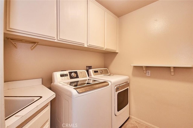 laundry area with baseboards, a sink, cabinet space, and washer and dryer