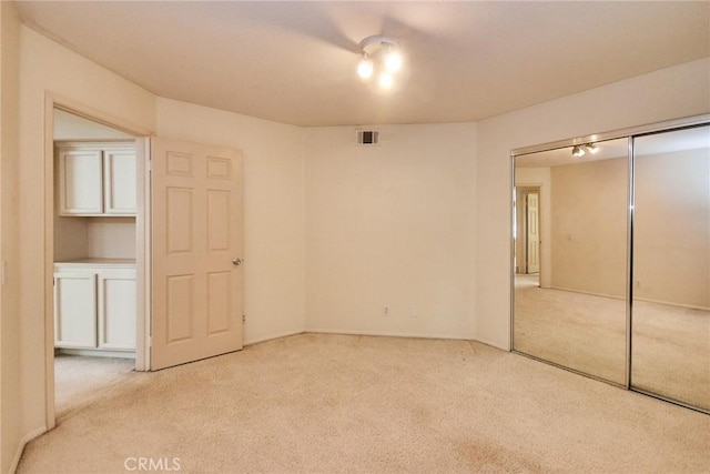 unfurnished bedroom featuring carpet, a closet, and visible vents