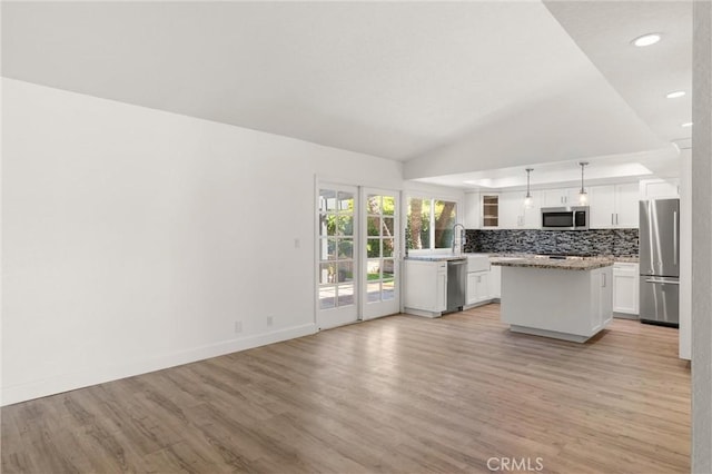 22122 Cape May Ln, Huntington Beach, CA 92646 - kitchen with light wood-style floors, white cabinetry, appliances with stainless steel finishes, and tasteful backsplash