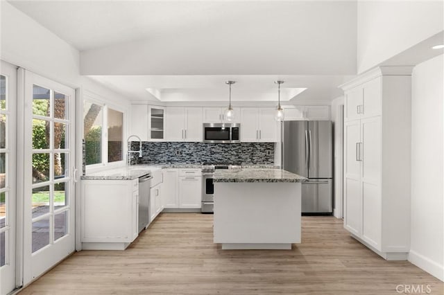 22122 Cape May Ln, Huntington Beach, CA 92646 - kitchen featuring white cabinetry, light stone counters, light wood finished floors, appliances with stainless steel finishes, and backsplash