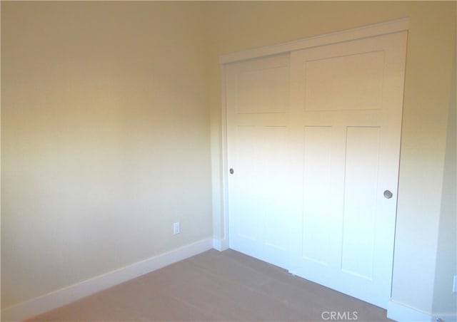 unfurnished bedroom featuring baseboards and a closet