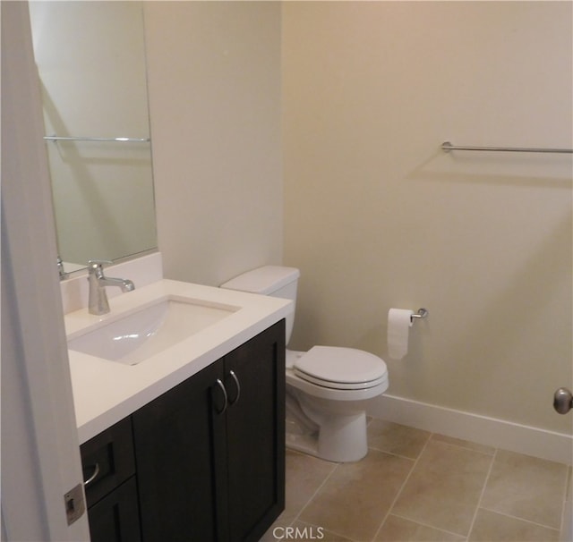 bathroom featuring vanity, baseboards, tile patterned flooring, and toilet
