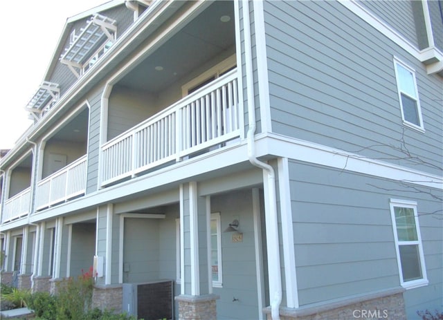 view of property exterior featuring a balcony and cooling unit