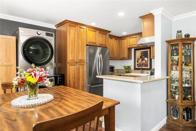 134 S Magnolia Ave Unit 21A, Anaheim, CA 92804 - kitchen featuring stacked washer and dryer, crown molding, light stone countertops, stainless steel refrigerator, and recessed lighting