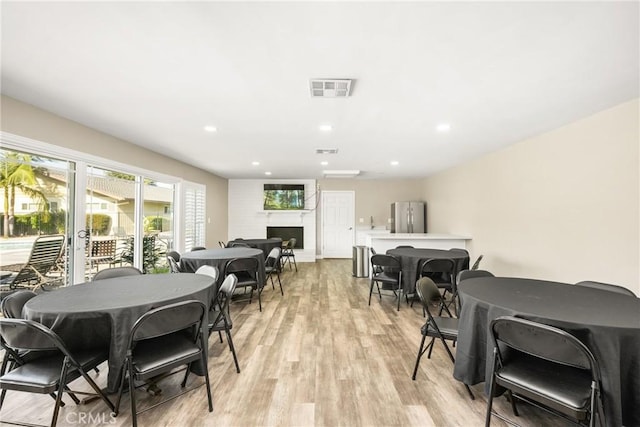 134 S Magnolia Ave Unit 21A, Anaheim, CA 92804 - dining area with a fireplace, recessed lighting, visible vents, and light wood-style floors