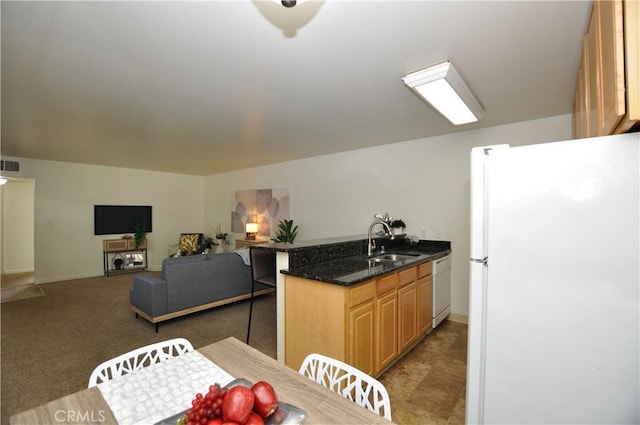 kitchen with a sink, white appliances, a peninsula, baseboards, and visible vents