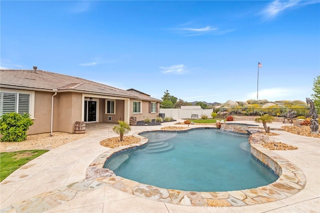 view of pool with a fenced backyard, a patio, and a pool with connected hot tub