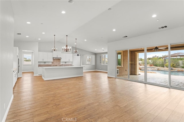 30404 Canyon Point Cir, Menifee, CA 92584 - unfurnished living room featuring a chandelier, light wood-style flooring, recessed lighting, ceiling fan, and high vaulted ceiling
