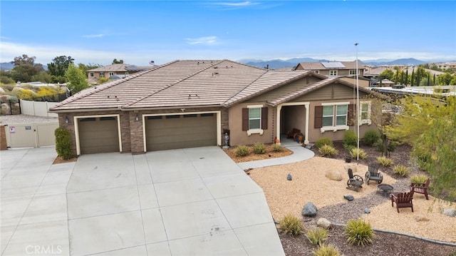single story home featuring a garage, a mountain view, driveway, and a tile roof