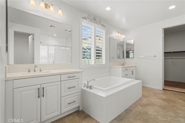 bathroom with visible vents, two vanities, a sink, and a bath