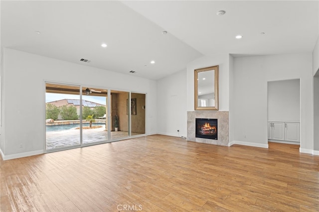 unfurnished living room with visible vents, a fireplace, lofted ceiling, light wood-style floors, and recessed lighting