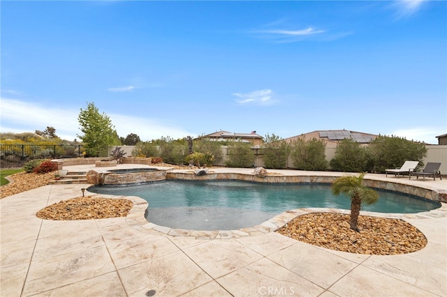 view of swimming pool featuring a pool with connected hot tub, a fenced backyard, and a patio area
