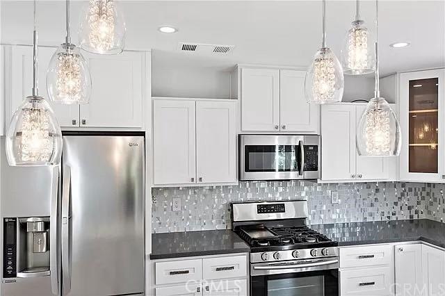 26872 Vista Del Mar, Dana Point, CA 92624 - kitchen with white cabinetry, dark countertops, appliances with stainless steel finishes, and visible vents