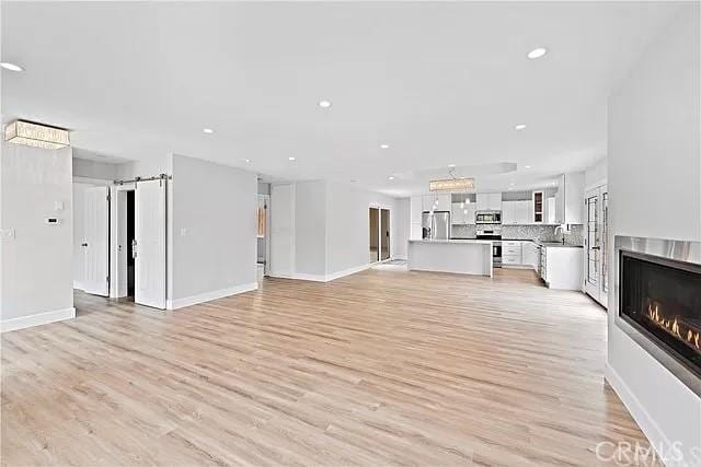 26872 Vista Del Mar, Dana Point, CA 92624 - unfurnished living room with recessed lighting, baseboards, a glass covered fireplace, and light wood finished floors