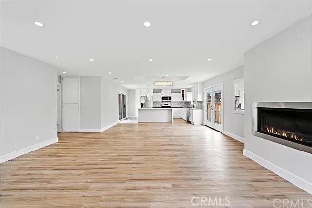 26872 Vista Del Mar, Dana Point, CA 92624 - unfurnished living room with recessed lighting, light wood finished floors, a glass covered fireplace, and baseboards