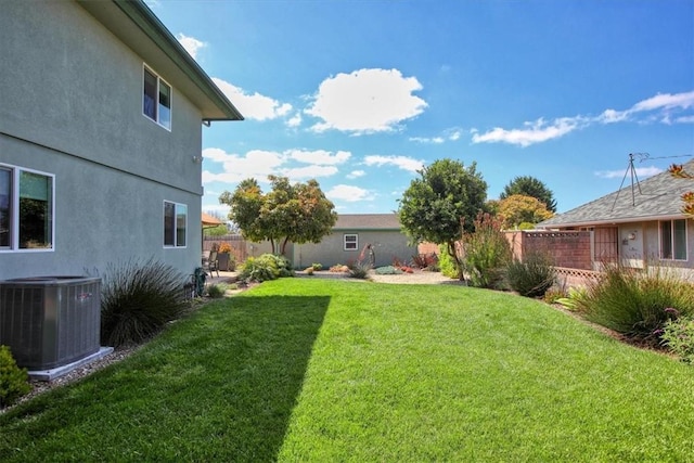 view of yard featuring fence and central AC unit