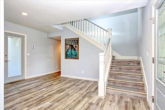 staircase with recessed lighting, baseboards, and wood finished floors