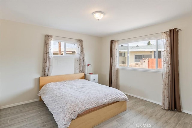 bedroom featuring baseboards and light wood-style flooring