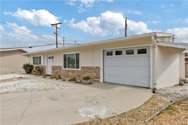 ranch-style house with a garage, driveway, and stone siding