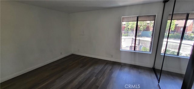 spare room featuring baseboards, dark wood-style floors, and french doors