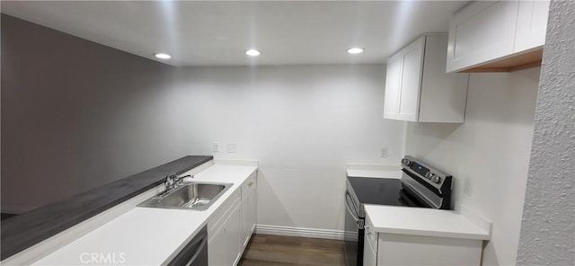 kitchen featuring stainless steel electric range, a sink, light countertops, dark wood-style floors, and recessed lighting
