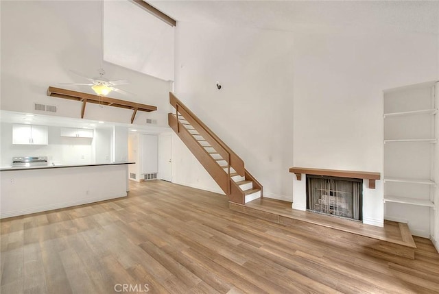 348 S Prospectors Rd Unit 8, Diamond Bar, CA 91765 - unfurnished living room featuring high vaulted ceiling, stairs, a fireplace, light wood-style flooring, and ceiling fan