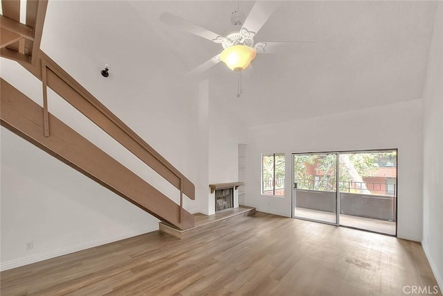 348 S Prospectors Rd Unit 8, Diamond Bar, CA 91765 - unfurnished living room with high vaulted ceiling, wood finished floors, a fireplace with raised hearth, ceiling fan, and baseboards