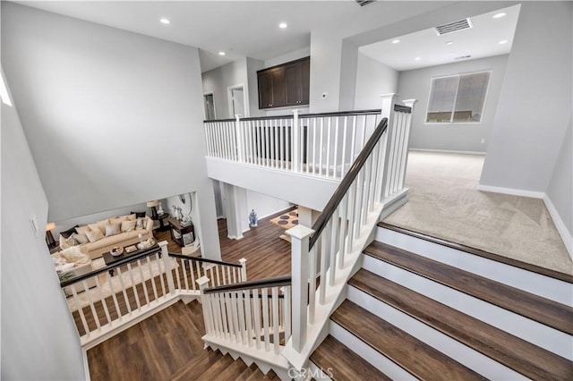 stairs featuring visible vents, recessed lighting, baseboards, and wood finished floors