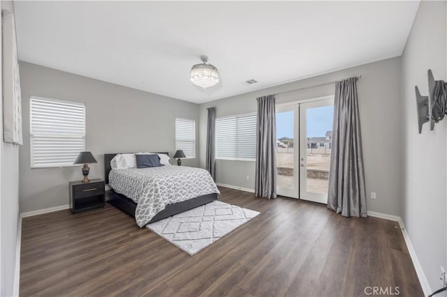 bedroom featuring visible vents, baseboards, wood finished floors, and access to outside