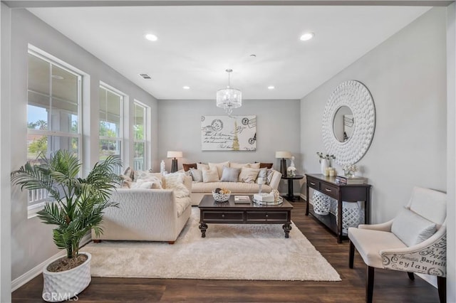 living area featuring an inviting chandelier, visible vents, recessed lighting, and dark wood-type flooring