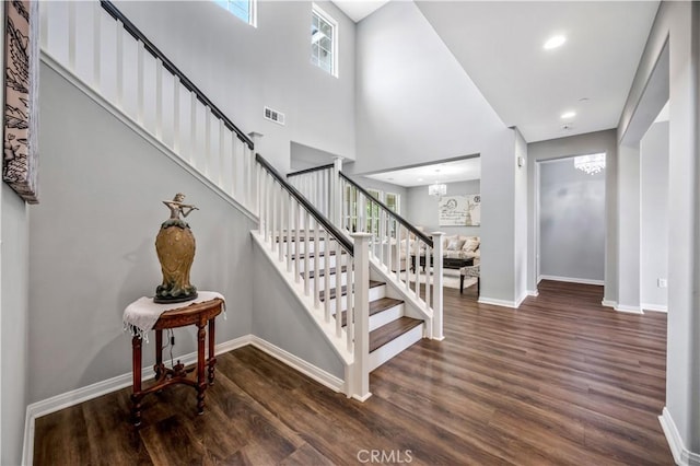 staircase featuring recessed lighting, baseboards, visible vents, and wood finished floors