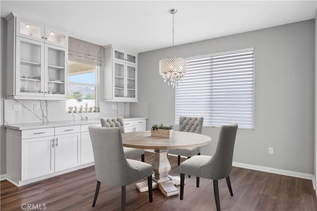 dining room with baseboards, dark wood finished floors, and a notable chandelier