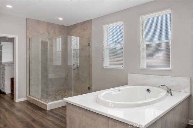 full bath with recessed lighting, baseboards, wood finished floors, a garden tub, and a stall shower